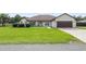 Single-story home with a brown garage door and green lawn at 13783 Se 8Th Ct, Ocala, FL 34480