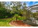 Landscaped backyard with lush greenery and screened enclosure at 8655 Sw 86Th Cir, Ocala, FL 34481