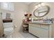 Bathroom with granite vanity, oval mirror, and updated fixtures at 6248 Sw 103Rd Street Rd, Ocala, FL 34476