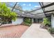 Covered courtyard with brick flooring, lush landscaping, and a water feature at 2305 Se 8Th St, Ocala, FL 34471