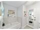 Bathroom with soaking tub, updated tile, and a large mirror at 2305 Se 8Th St, Ocala, FL 34471