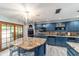 L shaped kitchen with blue cabinets, granite island and breakfast bar at 2305 Se 8Th St, Ocala, FL 34471