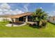 Home's backyard with patio, lush landscaping, and a view of palm trees at 15890 Sw 11Th Terrace Rd, Ocala, FL 34473