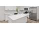 Modern kitchen with white cabinets, quartz countertops, and stainless steel appliances at 5 Emerald Trl, Ocala, FL 34472