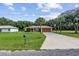 House exterior showcasing a large yard, driveway, and basketball court at 49 Fisher Way, Ocklawaha, FL 32179