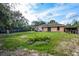 Backyard view of house, grassy area, and wooden fence at 49 Fisher Way, Ocklawaha, FL 32179