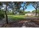 Backyard with grassy area, mature trees, and house at 49 Fisher Way, Ocklawaha, FL 32179