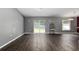Spacious living room with sliding glass doors and dark laminate flooring at 49 Fisher Way, Ocklawaha, FL 32179