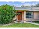 Front entrance with brown door and green shrubbery at 49 Fisher Way, Ocklawaha, FL 32179