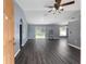 Spacious living room with dark gray vinyl flooring and ceiling fan at 49 Fisher Way, Ocklawaha, FL 32179