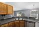Kitchen with dark countertops and double sink overlooking living room at 49 Fisher Way, Ocklawaha, FL 32179