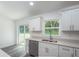 Kitchen features white cabinets, stainless steel dishwasher, and sliding door to backyard at 1 Pine Trace Trl, Ocala, FL 34472