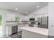 Modern kitchen with white cabinets, stainless steel appliances, and island at 1 Pine Trace Trl, Ocala, FL 34472