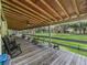 Spacious front porch overlooking the yard, featuring rocking chairs and an American flag at 11831 Sw Highway 484, Dunnellon, FL 34432