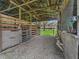 Rustic barn interior with wooden stalls and a dirt floor, offering ample space at 11831 Sw Highway 484, Dunnellon, FL 34432