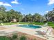 Inviting pool area with lounge chairs, surrounded by lush landscaping at 11831 Sw Highway 484, Dunnellon, FL 34432
