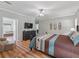 Spacious main bedroom with hardwood floors and a large TV at 11831 Sw Highway 484, Dunnellon, FL 34432