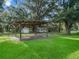 Covered structure in the backyard with a nearby shed, offering covered parking or storage at 11831 Sw Highway 484, Dunnellon, FL 34432