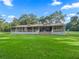 Ranch-style home with a large front porch, white railings and a well-maintained lawn at 11831 Sw Highway 484, Dunnellon, FL 34432