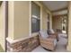 Covered porch with wicker chairs and stone accents at 9793 Sw 63Rd Loop, Ocala, FL 34481