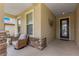 Front entry with stone accents, a dark door, and wicker chairs at 9793 Sw 63Rd Loop, Ocala, FL 34481