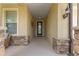 Front entry with stone accents, a dark door, and wicker chairs at 9793 Sw 63Rd Loop, Ocala, FL 34481