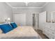 Bright bedroom with a queen-size bed, dresser, and double doors leading to the hallway at 9793 Sw 63Rd Loop, Ocala, FL 34481