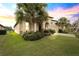 House exterior at sunset, featuring a tan stucco finish and palm trees at 9793 Sw 63Rd Loop, Ocala, FL 34481