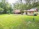 House back view with large backyard and trees at 1779 Ne 12Th St, Ocala, FL 34470
