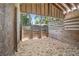 Empty horse stall with wood walls and wood shavings on the floor at 7137 & 7141 S Magnolia Ave, Ocala, FL 34476