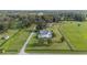 Aerial view showcasing a single-story home, surrounded by lush green fields and trees at 7137 & 7141 S Magnolia Ave, Ocala, FL 34476