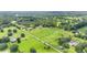 Aerial view showing a large property with a main house and outbuildings, surrounded by lush fields at 7137 & 7141 S Magnolia Ave, Ocala, FL 34476