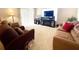 Living room with fireplace, two sofas and a large TV at 892 Nash Loop, The Villages, FL 32162
