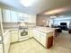 Kitchen features white cabinets, breakfast bar, and view into living room at 892 Nash Loop, The Villages, FL 32162