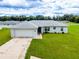 Single-story home with a two-car garage and lush lawn at 1436 Ne 161St Pl, Citra, FL 32113