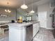 Modern kitchen with island, stainless steel appliances, and white cabinets at 1436 Ne 161St Pl, Citra, FL 32113