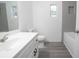 Bathroom with grey tile shower, white vanity, and grey wood-look flooring at 1750 Ne 180Th St, Citra, FL 32113