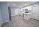 White kitchen cabinets, gray vinyl flooring, and stainless steel refrigerator at 1750 Ne 180Th St, Citra, FL 32113
