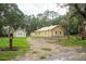 Yellow house with metal roof, detached garage, and large yard at 1750 Ne 180Th St, Citra, FL 32113