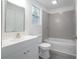 Bathroom with grey tile shower, white vanity, and grey wood-look flooring at 1750 Ne 180Th St, Citra, FL 32113