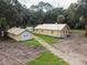 Yellow house with metal roof, detached garage, and large yard at 1750 Ne 180Th St, Citra, FL 32113