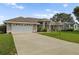 Home with a large driveway and landscaped yard at 5851 Sw 86Th Pl, Ocala, FL 34476