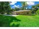 House backyard with lush green grass and mature trees at 1989 Nw 111Th Loop, Ocala, FL 34475