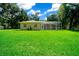 Backyard view showcasing a home with a screened enclosure at 1989 Nw 111Th Loop, Ocala, FL 34475