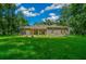 Single-story home with stone exterior, large yard, and covered porch at 1989 Nw 111Th Loop, Ocala, FL 34475