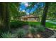 Stone house with lush green lawn and mature trees at 1989 Nw 111Th Loop, Ocala, FL 34475
