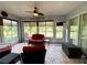 Bright sunroom featuring tiled flooring, comfy seating, and backyard access at 16376 Sw 13Th Ter, Ocala, FL 34473