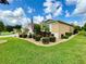 Landscaped yard with a tan house and American flag at 16376 Sw 13Th Ter, Ocala, FL 34473