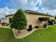 Landscaped side yard with tan house and manicured shrubs at 16376 Sw 13Th Ter, Ocala, FL 34473