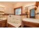 Bathroom with a jetted tub, double vanities, and a window at 7545 Ne 58Th Ave, Anthony, FL 32617